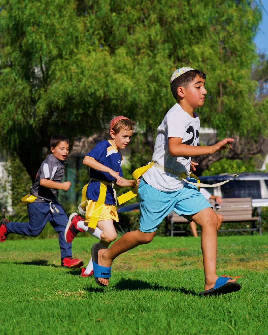 Children running together during an outdoor LA Sports World activity